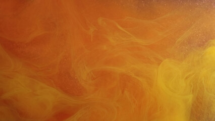 Fog fluid. Colorful watercolor. Bright cloud of orange paint alternately swirls on shiny abstract background. Light smoky blur veil dye in water.