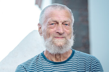 Mature man in retirement, enjoying time outdoors, smiling with a serene expression, blue eyes,...