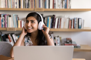 Interactive virtual learning. Confident young girl remote student in headset sit by notebook at...