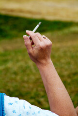 Smoking cigarette in the hand of an adult female