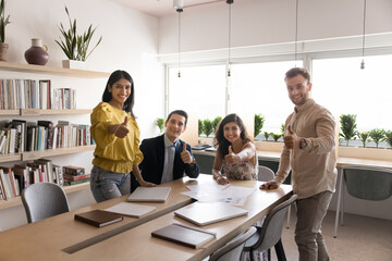Thumbs up for teamwork. Group portrait smiling motivated young scientists of diverse ethnicities feel team spirit create project at library show you like sign celebrate achieving success in research
