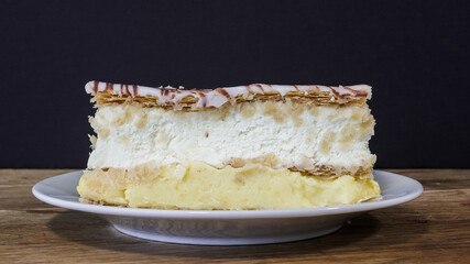 Delicious layered Napoleon dessert served on a plate with a dark background