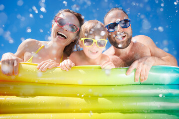 Happy family playing in waterpark. People having fun on summer vacation