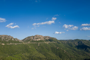 Fototapeta premium The road in the Sardinian countryside between Baunei and Dorgali in Europe, Italy, Sardinia, Baunei, in summer, on a sunny day.