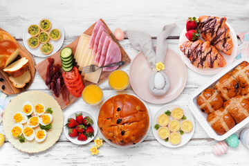 Easter breakfast or brunch table scene. Top view on a white wood background. Breads, quiche and an assortment of spring food items.
