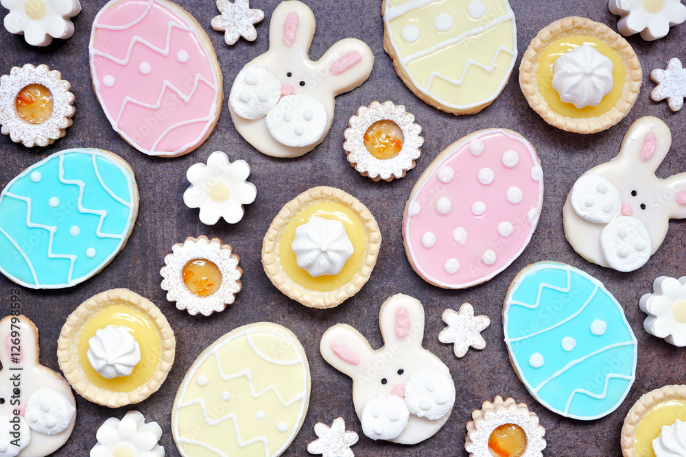 Poster easter or spring themed baking background with assorted cookies and sweet desserts. top view on a da