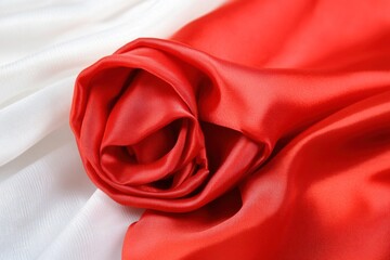 Luxurious red fabric showcases smooth texture and graceful folds, highlighting its vibrant color and elegance in stillness