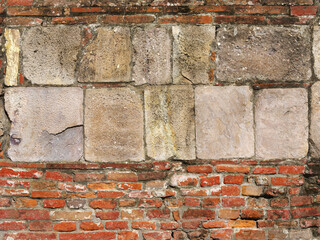 Ancient stone wall with red bricks as background