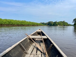 Obraz premium Front of wooden canoe and paddle on a tributary of the Amazon, Colombia.