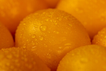 a large number of ripe orange tomatoes that are on the table