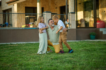 Grandfather and grandchildren having fun playing in the backyard