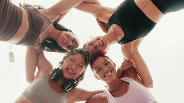 Four diverse female friends in activewear huddle together, smiling, before or after a workout. They embody fitness, friendship, and community.