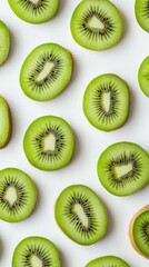 Fototapeta premium Bright green kiwi slices are beautifully laid out in a symmetrical pattern against a clean white background, showcasing their vibrant colors and inviting texture
