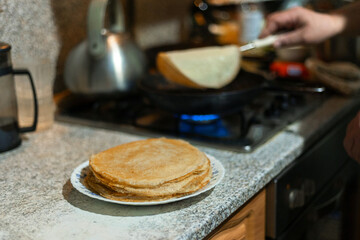 On the plate is a stack of pancakes.The process of making pancakes for breakfast .