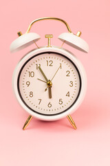 White alarm clock on a pink background. Retro alarm clock. Retro Watches