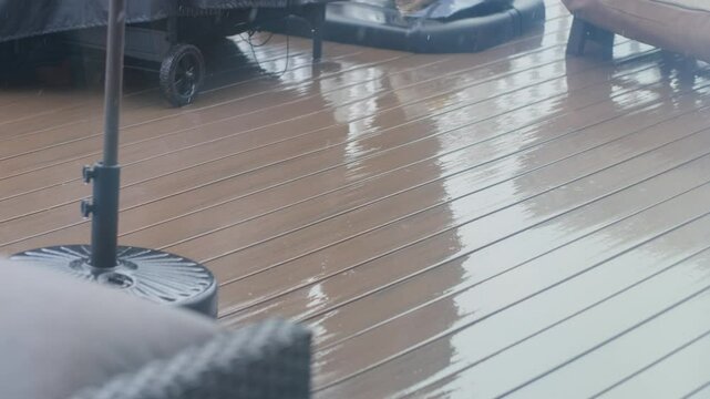 Heavy rain creates puddles on suburban deck during afternoon hours