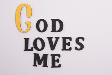 ‘God Loves Me’ Black latter's, yellow G white background  