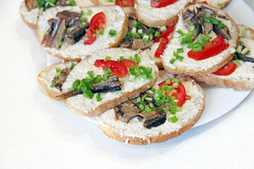 toasts with sprats and green onions on plate. Sandwiches for breakfast