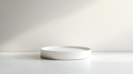A minimalist white ceramic plate sits elegantly on a marble surface, illuminated by soft, natural light, creating a serene and modern ambiance.