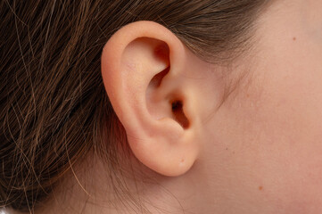 A close-up view of a human ear, showcasing details of the skin and hair.
