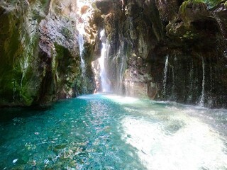 Crystal-clear turquoise water and cascading waterfalls in the Kourtaliotiko Gorge, Crete,...
