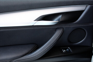 Door trim. Car door control panel. Car interior. Window lifters control. Car inside door chrome...