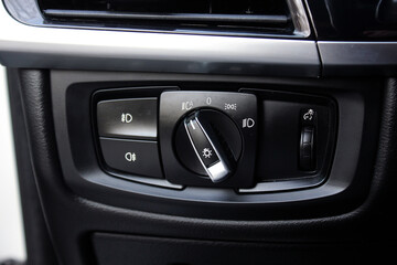 Fototapeta premium Light control panel in premium car. Car light switch. Dashboard for switching on the headlights and fog lights. 