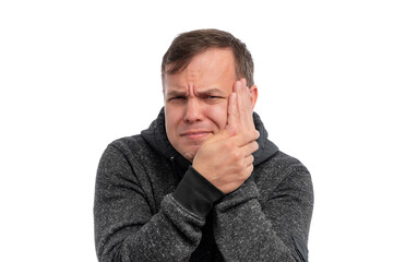 A young man grimacing while holding his jaw, expressing discomfort against a white background.