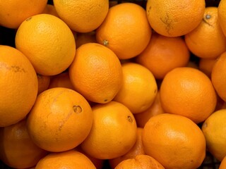 Ripe fresh organic oranges in box on the shelf of a fruit supermarket are displayed for sale