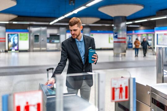 Businessman using his contactless credit card to enter subway station