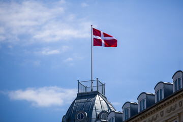 Fototapeta premium The national flag of Denmark – a symbol of independence and pride, waving against the sky