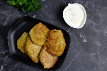 Potato pancakes with sour cream and parsley, top view