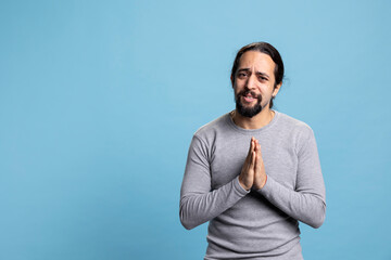 Religious person praying and begging for forgiveness in front of camera, showing belief in...