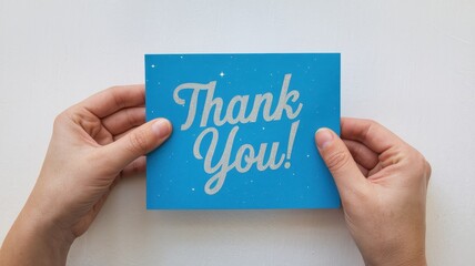 Hands holding a blue thank you greeting card message