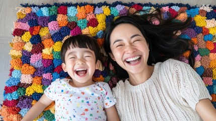 Laughing mother and child lying on a colorful, textured rug enjoy a playful tickling session, capturing pure joy and familial bond.