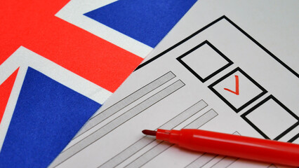 Voter marks box with red marker on paper ballot. Democratic elections in UK. Union Jack in background. Electoral process reflects citizen participation in shaping government through fair voting system