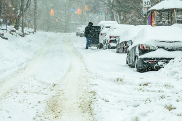 time to dig out: snow covered cars parked on snow choked residential street after a major winter...