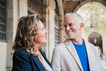 Joyful Mature Couple Engaging in Heartfelt Conversation with Warm Smiles and Shared Laughter While Enjoying Each Other's Company in a Beautiful Outdoor Setting Full of Life and Energy