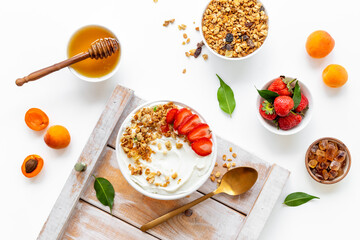 Healthy breakfast flat lay. Yogurt with muesli and strawberry in bowl. Top view