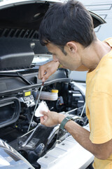 Mechanic checking motor oil level in camper van engine.