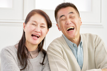 シニアの夫婦　笑顔　カメラ目線　ポートレート　リビング
