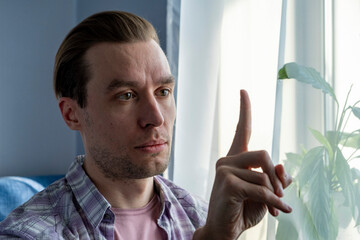 Portrait of a man who making a gymnastic exercise for the eyes at home