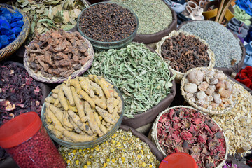 Curry in root and various spices displayed in a local bazaar market in Marrakesh