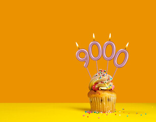 Candles forming the number 9000 - Yellow background.