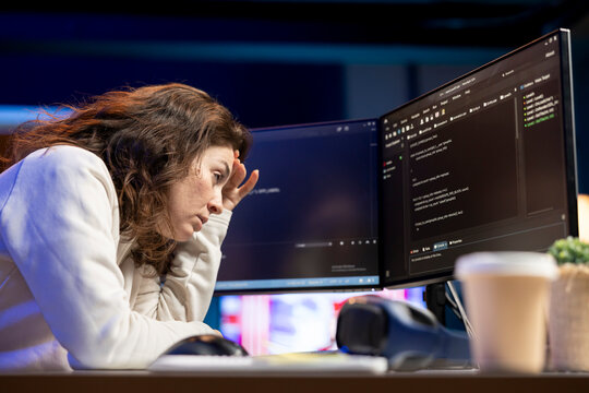Tired woman hurting from too much stress accumulated while doing software quality assurance, reading source code on computer. Engineer suffers from headache after inspecting coding on PC for too long