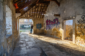 Fototapeta premium 40-year-old white European man among the ruins of an old abandoned and vandalized cork factory in the city of Barreiro, Portugal.
