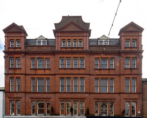 Fototapeta premium A detailed view of the Salisbury Building, showcasing its red brick facade and symmetrical architectural design. The structure features decorative gables