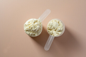 Protein powder. Vanilla flavour of protein powder in scoops, closeup.