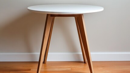 A small round dining table with a white top and wooden legs, perfect for a minimalist apartment