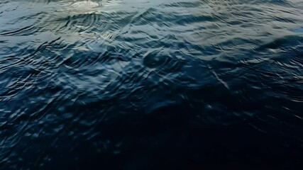 Close slow motion video dark water waves creating dramatic reflections offering entrancing natural backdrop hypnotic feel ideal tranquil video introductions